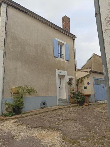 Cette maison ancienne dispose d'une porte blanche et d'une fenêtre. dans l'établissement Ancienne Boulangerie, à Saint-Sauveur-en-Puisaye