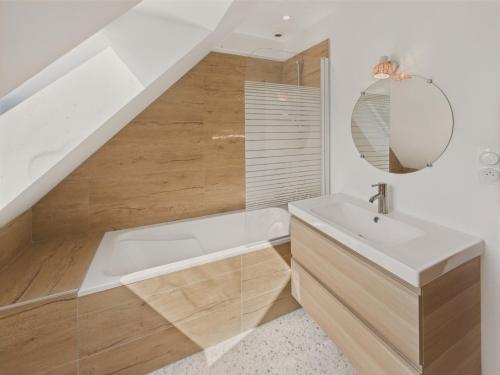 a bathroom with a bath tub and a sink at Maison pour 6 avec jardin à 1 km de la plage in Penmarcʼh