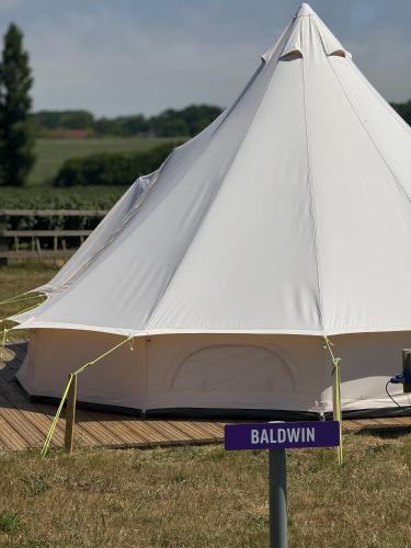 a large white tent with a sign in the grass at Hill Fruit Farm Glamping in Trunch