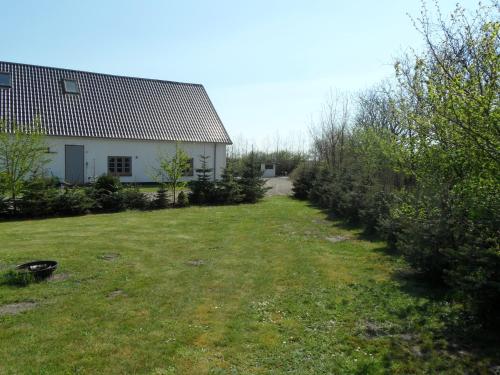 a yard with a house and a building and some bushes at Motel Herning in Kibæk