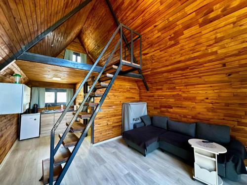 a living room with a staircase in a wooden wall at Nefesurla Bungalov 5 in Urla