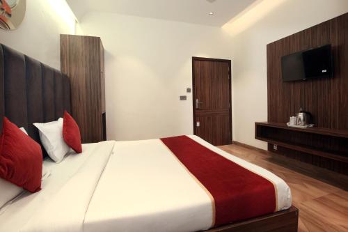a bedroom with a large bed with red pillows at Park Plaza Hotel Near Golden Temple in Amritsar