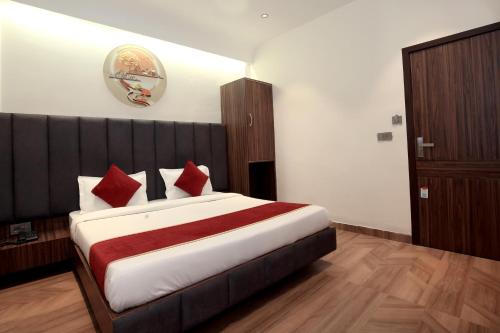 a bedroom with a large bed with red pillows at Park Plaza Hotel Near Golden Temple in Amritsar