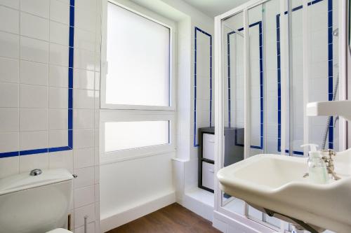 une salle de bain avec un lavabo et des toilettes et une fenêtre dans l'établissement 300 m de la plage, terrasse, superbe maison pour 4, à Dinard