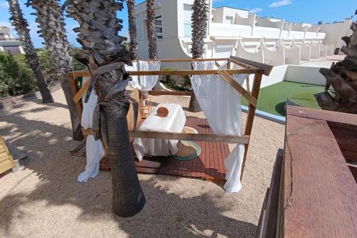 une chambre avec une table et un arbre dans l'établissement Naturiste Cap d'Agde Jardin d'Eden-Réservé aux Couples-Swimming Pool Jaccuzzi, à Agde