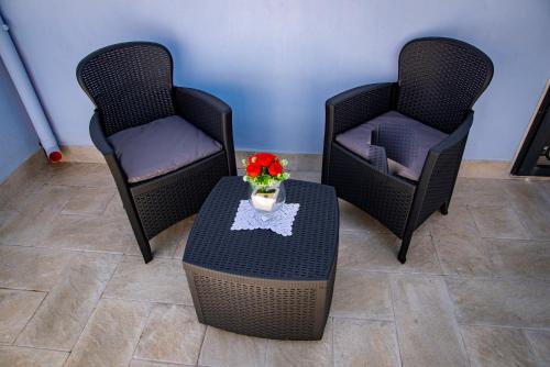 three chairs and a table with a vase of flowers on it at Rosa azzurra in Casamassima