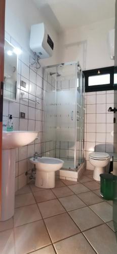 ein Badezimmer mit zwei Toiletten, einer Dusche und einem Waschbecken in der Unterkunft Casa Vacanze Mari Pintau in Geremèas
