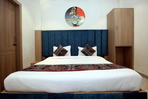 a bedroom with a large white bed with a blue headboard at Park Plaza Hotel Near Golden Temple in Amritsar