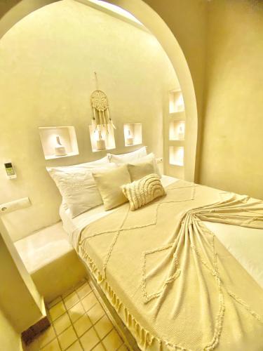 a bedroom with a large white bed with an archway at Riad Oum h&N B&B in Marrakech