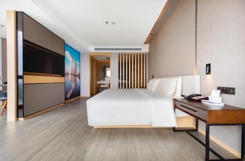a bedroom with a large white bed and a desk at Atour S Hotel Nanshan Haofang Tianji Shenzhen深圳南山豪方天际亚朵S酒店 in Shenzhen