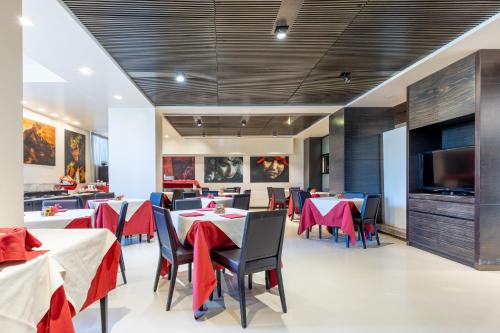 a restaurant with tables and chairs and a flat screen tv at Wall Art Hotel & Residence in Prato