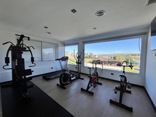 a gym with three elliptical machines and a large window at Pie de Piedra Hotel Boutique in Sierra de la Ventana