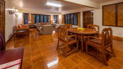 a living room with a wooden table and chairs at Tranquil Resort - Blusalzz Collection, Wayanad - Kerala in Ambalavayal