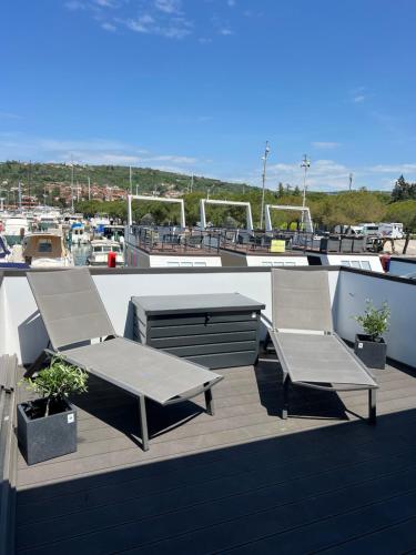a patio with two chairs and a table on a roof at Floating House - SEA SUITE in Portorož