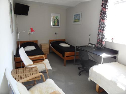 a room with two beds and a desk and a desk at Motel Herning in Kibæk
