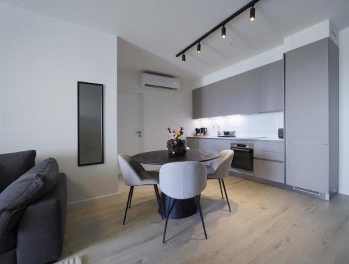 a dining room with a table and chairs and a kitchen at Rooftop Sunset Garden by Staycom in Pamboula