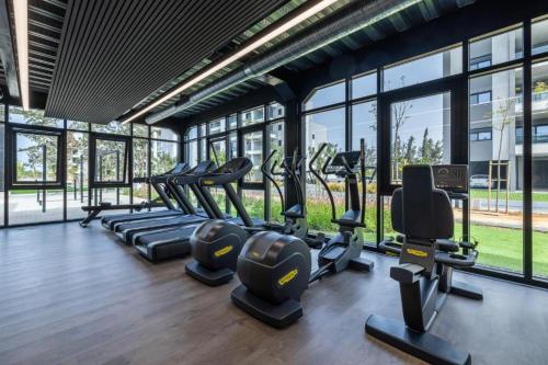a gym with rows of treadmills and elliptical machines at Rooftop Sunset Garden by Staycom in Pamboula