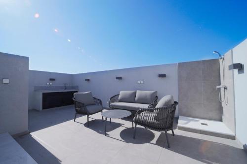a living room with a couch and chairs in a room at Rooftop Sunset Garden by Staycom in Pamboula