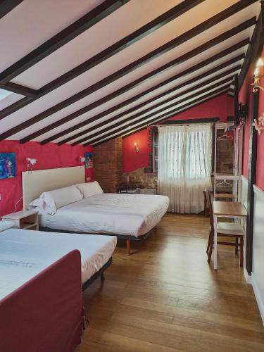 a room with two beds and a table and chairs at Posada el Remanso de Trivieco in La Cavada
