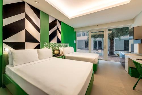 a bedroom with a white bed and a green wall at Astoria Current in Boracay