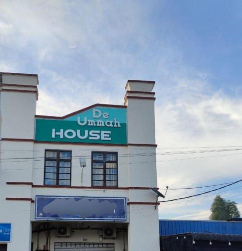 a building with a green sign on top of it at Deummah Guest Room in Cukai