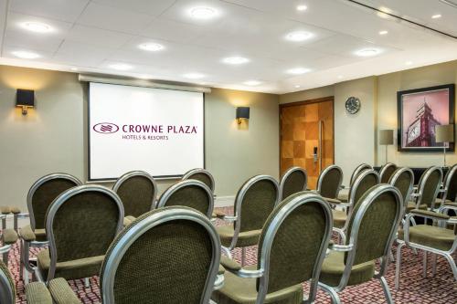 a conference room with chairs and a projector screen at Crowne Plaza London Ealing by IHG in London