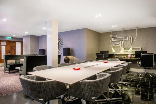 a conference room with a table and chairs at Crowne Plaza London Ealing by IHG in London