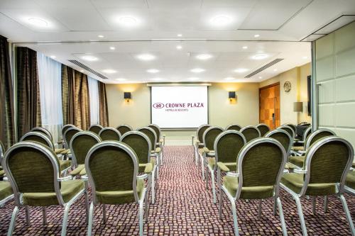 a conference room with chairs and a projector screen at Crowne Plaza London Ealing by IHG in London