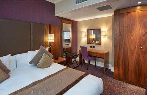 a hotel room with a bed and a desk at Crowne Plaza London Ealing by IHG in London