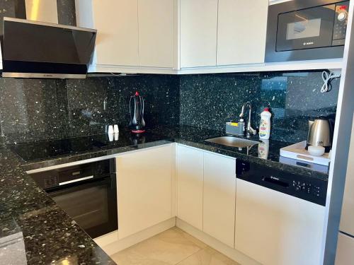 a kitchen with white cabinets and a sink at Boutique 16 - Alanya Experience in Alanya