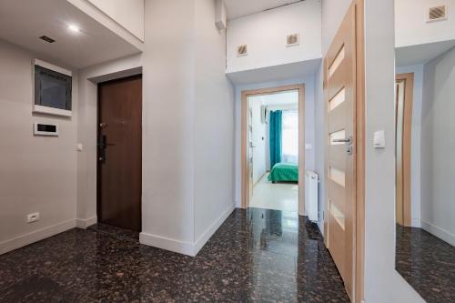 a hallway with white walls and a door and a bedroom at Amber Apartments in Gdańsk