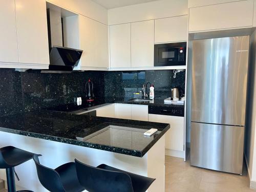 a kitchen with black granite counter tops and a refrigerator at Boutique 16 - Alanya Experience in Alanya