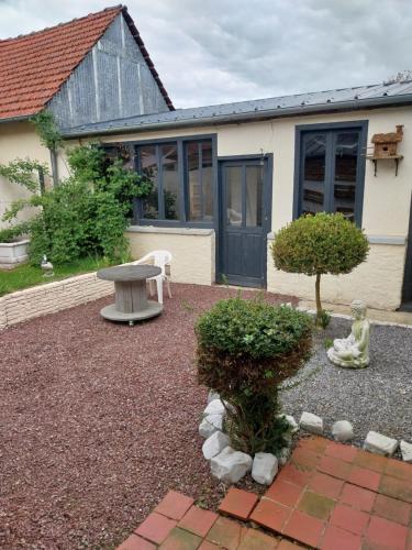un jardin avec une table et un banc devant une maison dans l'établissement maison beauval, à La Celle-sous-Gouzon