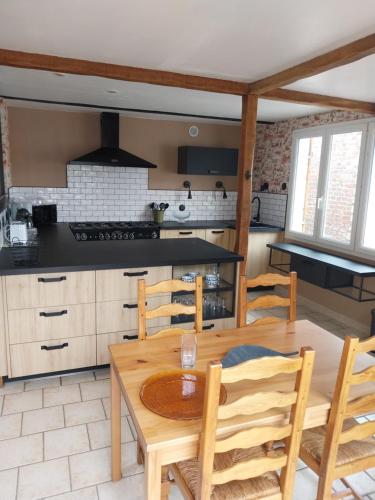 une cuisine avec une table et des chaises en bois dans l'établissement maison beauval, à La Celle-sous-Gouzon