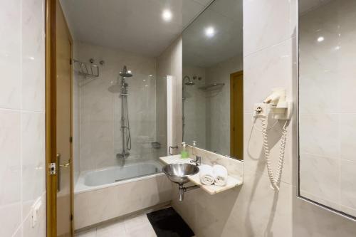 a bathroom with a sink and a bath tub at Gran Vía Sun in Barcelona