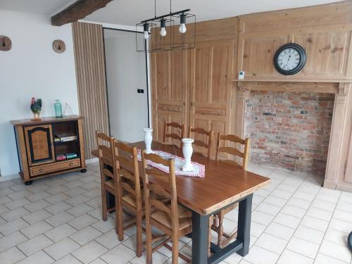 une salle à manger avec une table et une horloge murale dans l'établissement maison beauval, à La Celle-sous-Gouzon