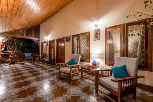 a living room with chairs and a table at Tranquil Resort - Blusalzz Collection, Wayanad - Kerala in Ambalavayal