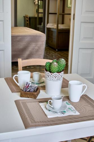 a table with coffee cups and a cactus on it at Casa Zizzi - appartamento romantico per 2 in Puglia in Montalbano