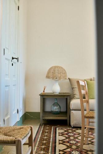 a living room with a couch and a table with a lamp at Casa Zizzi - appartamento romantico per 2 in Puglia in Montalbano