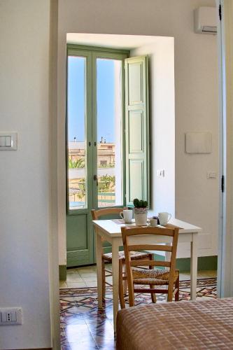 a room with a table and chairs and a window at Casa Zizzi - appartamento romantico per 2 in Puglia in Montalbano