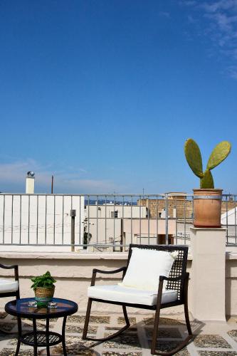 a patio with a chair and a table on a roof at Casa Zizzi - appartamento romantico per 2 in Puglia in Montalbano