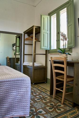 a bedroom with a bed and a desk and shelves at Casa Zizzi - appartamento romantico per 2 in Puglia in Montalbano