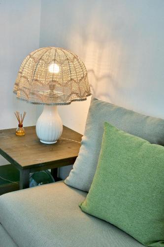 a lamp sitting on a table next to a couch at Casa Zizzi - appartamento romantico per 2 in Puglia in Montalbano