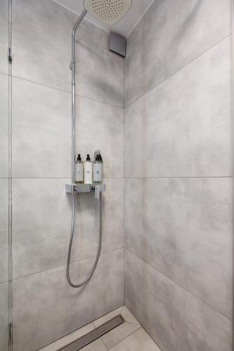 a shower with a shower head in a bathroom at Nowy Hotel Monika - by Upstairs in Kraków