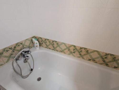a bath tub with a faucet in a bathroom at Studio cosy Anemone in Luchon