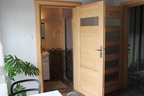 a wooden door in a room with a bathroom at Pokoje Gościnne Сisza in Białowieża