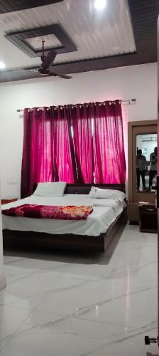 a bedroom with a bed with a pink curtain at Hill view in Haldwāni
