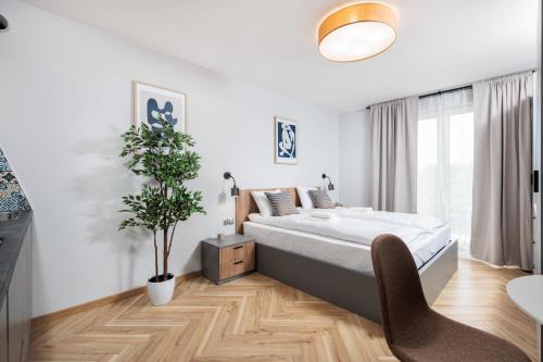 a bedroom with a large bed and a potted plant at Nowy Hotel Monika - by Upstairs in Kraków