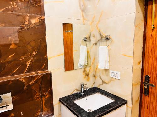 a bathroom with a sink and a mirror at South Haven Residency - South Extension South Delhi in New Delhi