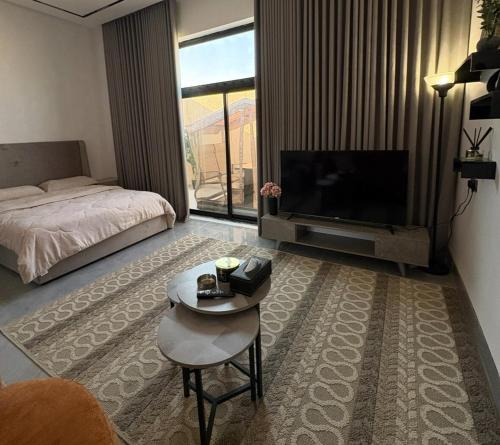 ein Wohnzimmer mit einem Bett und einem Fernseher in der Unterkunft A new studio near the airport in Quai